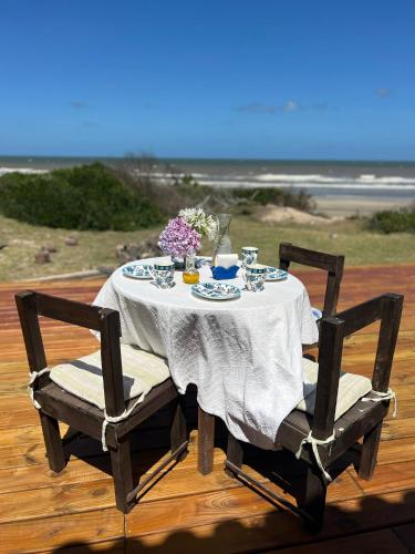 a table with two chairs and a table with flowers at Guesthouse Entre Campo y Mar in La Coronilla