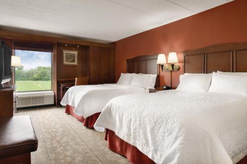 a hotel room with two beds and a window at Hampton Inn Cincinnati Kings Island in Mason