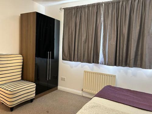 a bedroom with a bed and a chair and a window at 30% Off Monthly Stay/2bed /Erith in Erith