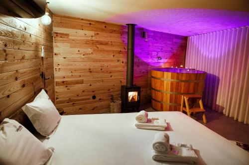 um quarto com uma cama com lareira e iluminação roxa em Carvalheira Country House - Gerês em Braga