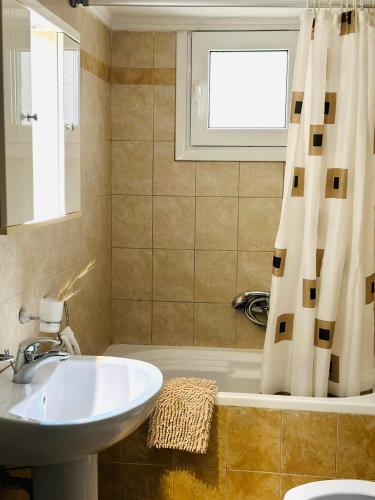 baño con lavabo y cortina de ducha en Luxury CityCenter Apartment, en Xanthi