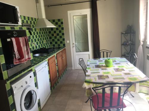 une cuisine avec une table et une machine à laver dans l'établissement Casa maria, à Porto-Vecchio