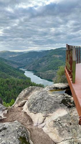 a bench sitting on top of a mountain overlooking a lake at Casa da Oliveira in Pegarinhos