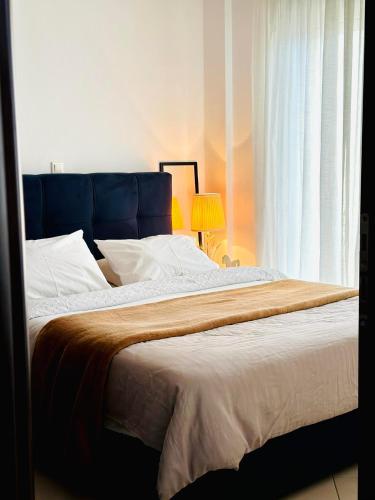 1 dormitorio con 1 cama grande y cabecero azul en Luxury CityCenter Apartment, en Xanthi