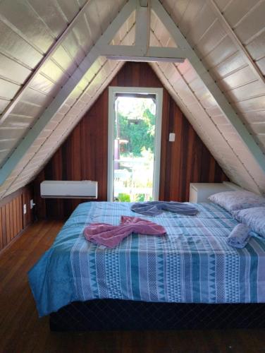 a bedroom with a bed in a attic at Cananéia Chalé 23 in Ilha Comprida