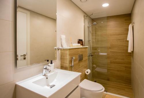 La salle de bains est pourvue d'un lavabo, de toilettes et d'une douche. dans l'établissement Duplex Delight in Al Raha, à Abu Dhabi