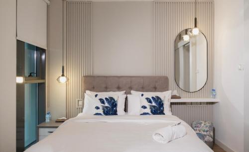 - un lit avec des oreillers bleus et blancs et un miroir dans l'établissement Duplex Delight in Al Raha, à Abu Dhabi