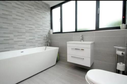 bagno con vasca bianca e lavandino di Luxury house in solihull a Olton