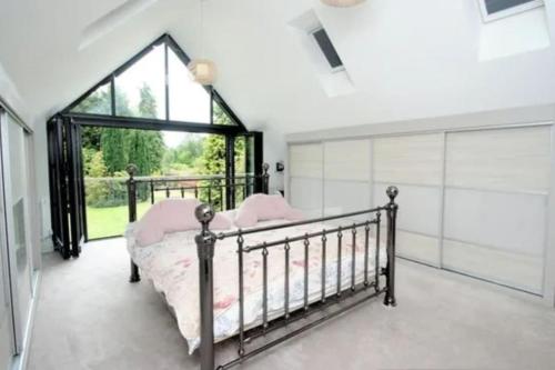 una camera con un letto e una grande finestra di Luxury house in solihull a Olton