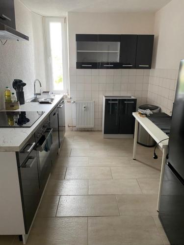 a kitchen with black appliances and a tile floor at Monteurwohnung für bis zu 5 Personen in Marpingen
