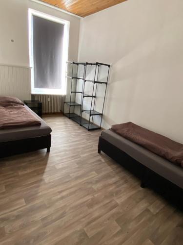 una camera con 2 letti e un pavimento in legno di Monteurwohnung für bis zu 5 Personen a Marpingen