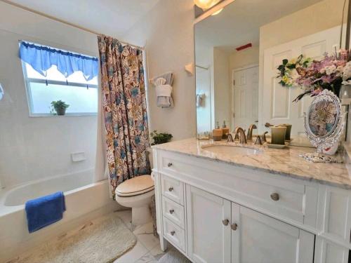 a bathroom with a sink and a toilet and a tub at Elysian deluxe villa in Davenport