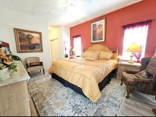 a bedroom with a large bed with red walls at Elysian deluxe villa in Davenport