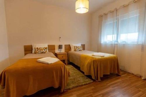 a bedroom with two beds and a window at Casa dos Gansos in Perais