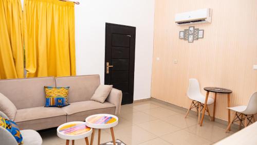 a living room with a couch and a yellow curtain at Hotel Djigui in Abidjan