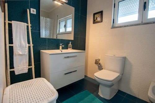 a bathroom with a white toilet and a sink at Casa dos Gansos in Perais