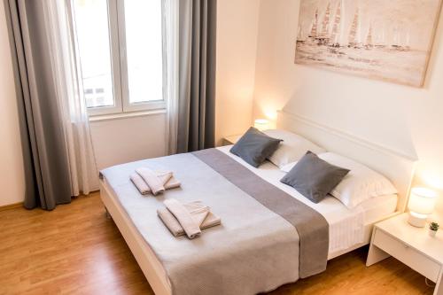 Un dormitorio con una cama grande con dos almohadas encima. en Apartments Ćurić, en Trogir