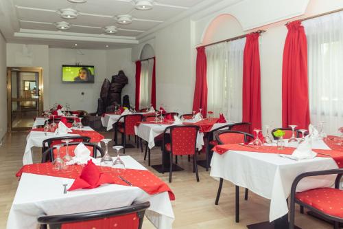 um restaurante com mesas e cadeiras vermelhas e brancas em Hotel Djigui em Abidjan