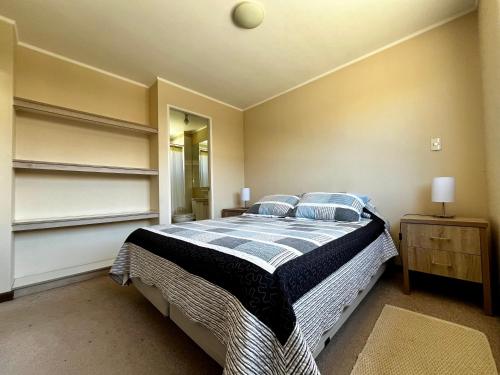 Un dormitorio con una cama con sábanas azules y blancas. en Casa Pucón, en Pucón