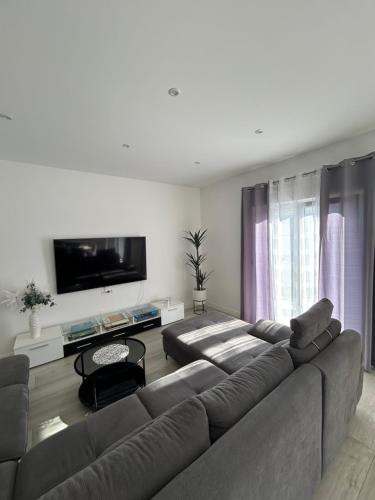 uma sala de estar com um sofá e uma televisão de ecrã plano em Stunning apartment Josipa em Kaštela