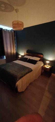 une chambre avec un grand lit et un mur bleu dans l'établissement Au Bon Accueil, à Feuquières