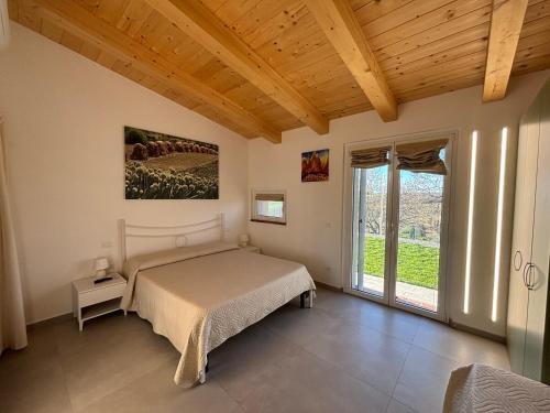 1 dormitorio con cama y ventana grande en Agriturismo Casale Gambacane, en Castelvecchio