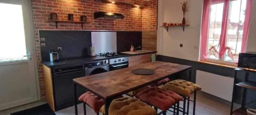 uma cozinha com uma mesa de madeira e um fogão em Au Bon Accueil em Feuquières