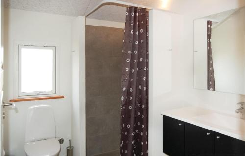 a bathroom with a shower curtain and a toilet at Awesome Home In Haderslev With 4 Bedrooms, Sauna And Indoor Swimming Pool in Kelstrup