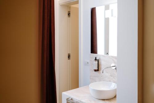 a bathroom with a white sink and a mirror at Aeris Suite & Relax in Polignano a Mare