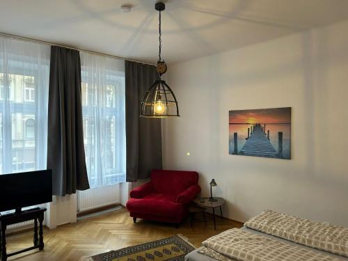 salon z czerwonym krzesłem i łóżkiem w obiekcie Paky Appartements 00406 w Wiedniu