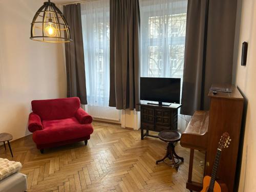 salon z czerwonym krzesłem i telewizorem w obiekcie Paky Appartements 00406 w Wiedniu