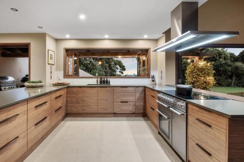a kitchen with wooden cabinets and stainless steel appliances at Villa Rangihoua in Omiha