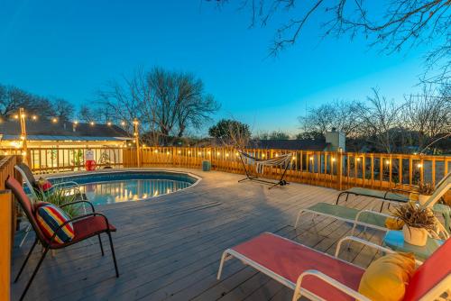 a deck with chairs and a swimming pool at night at Game Room, POOL & Fire pit at the Medical center in San Antonio