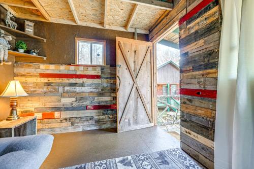 um quarto com uma parede de madeira e uma porta de celeiro em Smoky Mountain Cabin with Camping Area and Fire Pit! em Whittier