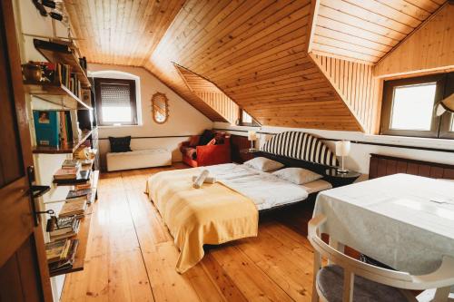 Pokój na poddaszu z łóżkiem i kanapą w obiekcie Inhauser Pincészet&Guesthouse&Restaurant w mieście Somlószőlős