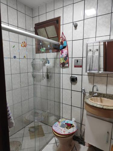 een badkamer met een douche, een toilet en een wastafel bij Suíte independente a 10 minutos da praia in Vila Velha