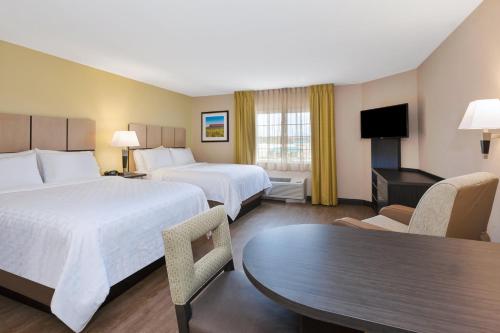 Habitación de hotel con 2 camas y mesa en Candlewood Suites Rocky Mount, an IHG Hotel, en Rocky Mount