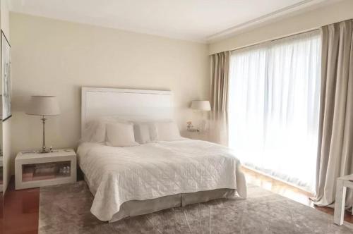 um quarto branco com uma cama e uma grande janela em Penthouse Roof 6 pieces à Monaco em Monte Carlo