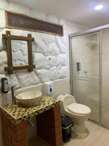y baño con lavabo y aseo. en Hotel Tekal del Rio en Puerto Boyacá