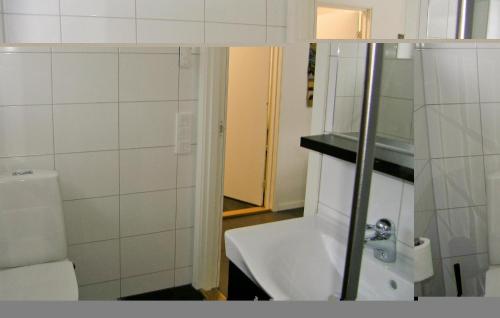een witte badkamer met een wastafel en een toilet bij Cozy Home In Steninge With Wifi in Steninge
