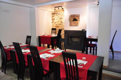 a dining room with tables and chairs and a fireplace at Casa dos Hospitalarios in Alvaro