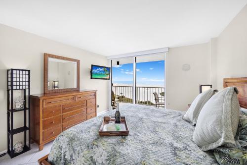 a bedroom with a bed with a dresser and a mirror at South Seas Tower 3-905 in Marco Island