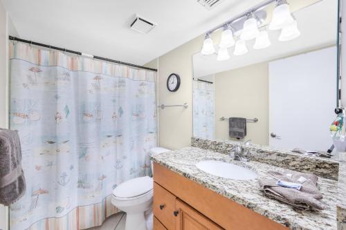 a bathroom with a sink and a toilet and a shower curtain at South Seas Tower 3-905 in Marco Island
