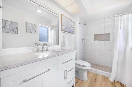 La salle de bains blanche est pourvue d'un lavabo et de toilettes. dans l'établissement 320 Marco Lake Drive, à Marco Island
