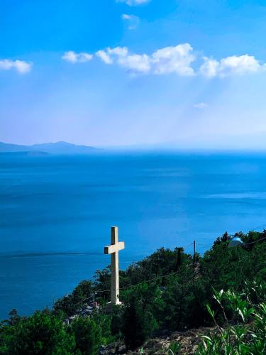 a cross on top of a hill near the ocean at Pelagos Seafront Accommodation - George in Myrties