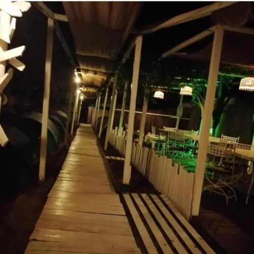a dock with tables and chairs in a restaurant at night at La Cort in Vama Veche