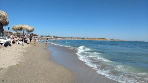 a group of people on a beach with the ocean at La Cort in Vama Veche