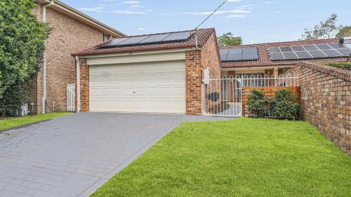a brick house with a garage and a driveway at Tranquil At Hibbard - 21 Hibbard Drive in Port Macquarie