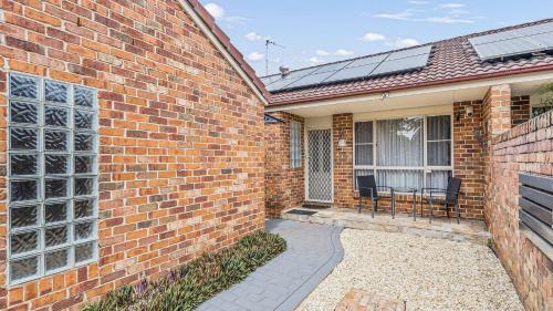 a brick house with solar panels on the side of it at Tranquil At Hibbard - 21 Hibbard Drive in Port Macquarie