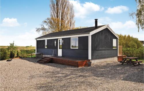 a black and white house with a picnic table and a bench at Two-Bedroom Holiday Home In Otterup in Otterup